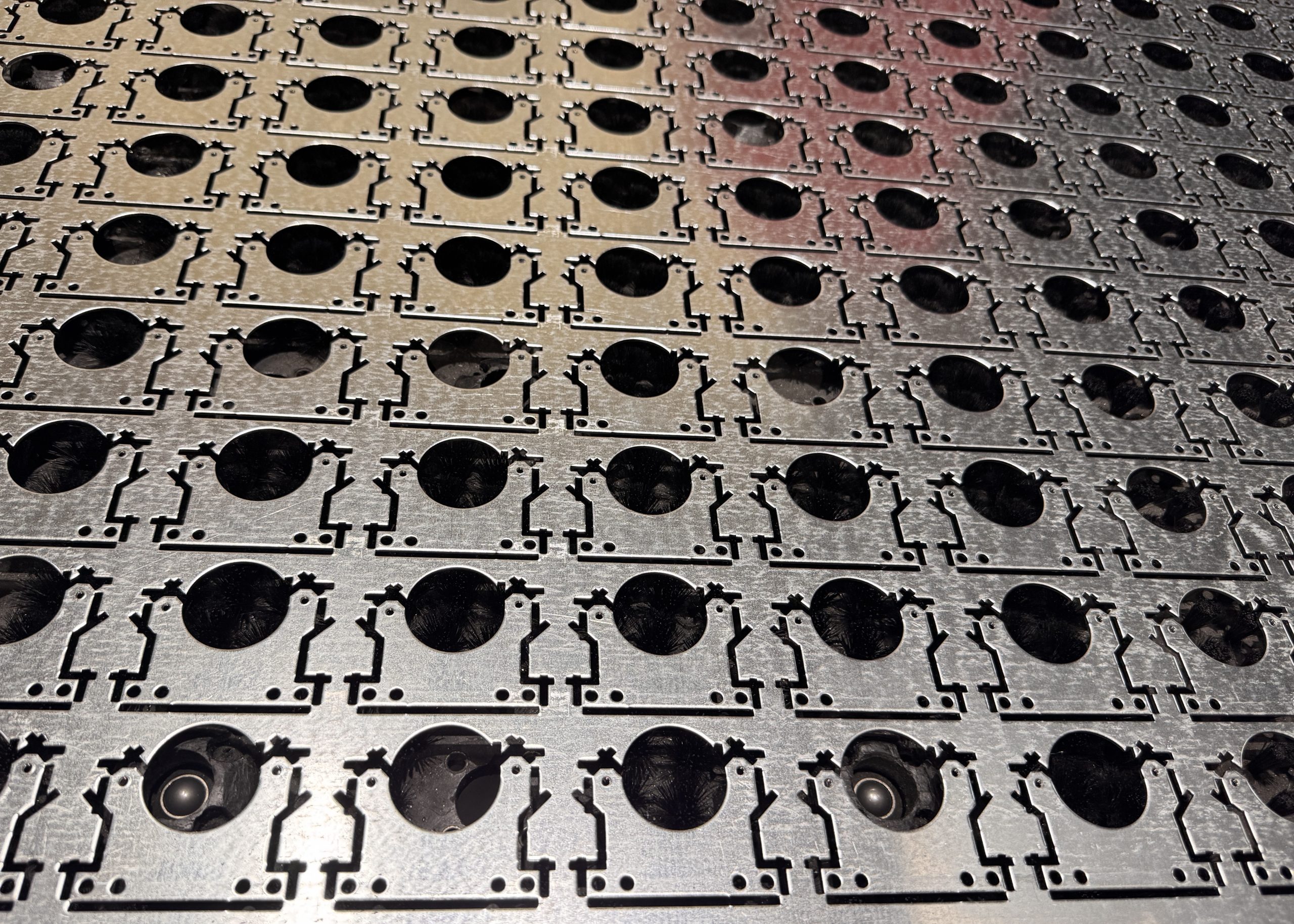 Rows of metal speaker grilles or vents cast with circular openings in a gritty industrial pattern.